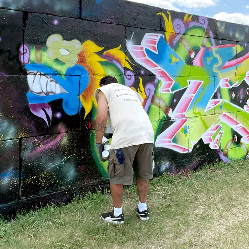 Artist painting graffiti mural